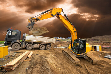 excavator working on construction site with dramatic sky