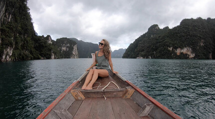 Young woman traveler on longtail boat trip at island hopping in Cheow Lan Lake - Wanderlust and travel concept with adventure girl tourist wanderer on excursion in Thailand