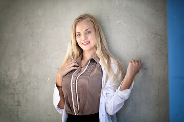 Portrait of young beautiful woman blonde hair standing against wall with copy space