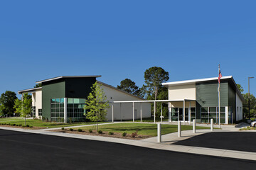 Modern generic green and white office business building with large American flag and landscaping