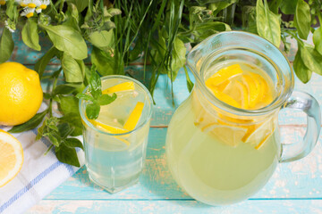 Two mason jar glasses of homemade lemonade on a rustic wooden background