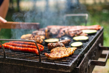 Closeup of steak barbecues cooking grilling on charcoals. Vertical. Assorted delicious grilled meat with vegetables over the coals on a barbecue.