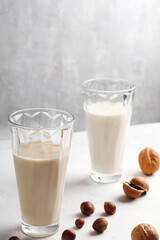 Natural breakfast. In glass glasses, nut milk on a light background. Organic vegetarian drinks. Health concept. Copy space