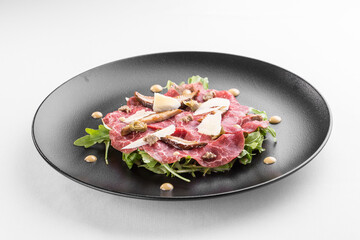 Meat Carpaccio with Parmesan Cheese and rocket salad isolated on white background