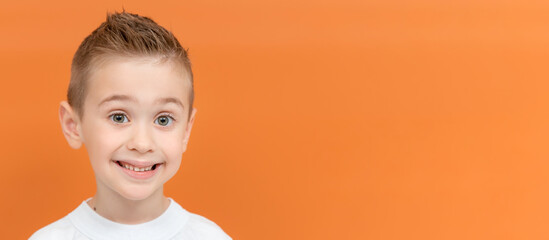 Happy cute preschooler kid in casual clothes on color background. Studio portrait of five year old boy. Banner, copy space.