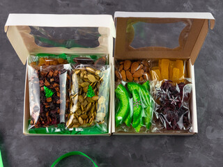 Gift box with set of different dried fruits nuts citrus individually wrapped flat lay. Healthy food...