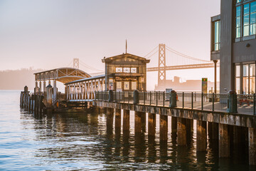 Incredible view of the pier and embankment in San Francisco at sunrise, the Oakland Bay Bridge is...