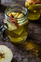 A refreshing jug of apple cider on wood table