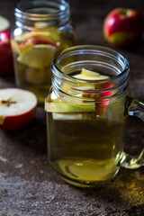 A refreshing jug of apple cider on wood table
