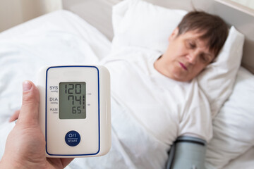 Providing first aid to an elderly woman. Measurement of blood pressure with a tonometer. Grandma...