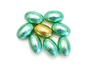 Chocolate easter eggs in colorful foil on white background