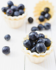 Chokeberry fruit in yellow cup cake on a light wooden boards.