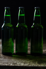 Beer bottles in a row on dark wood background, close up