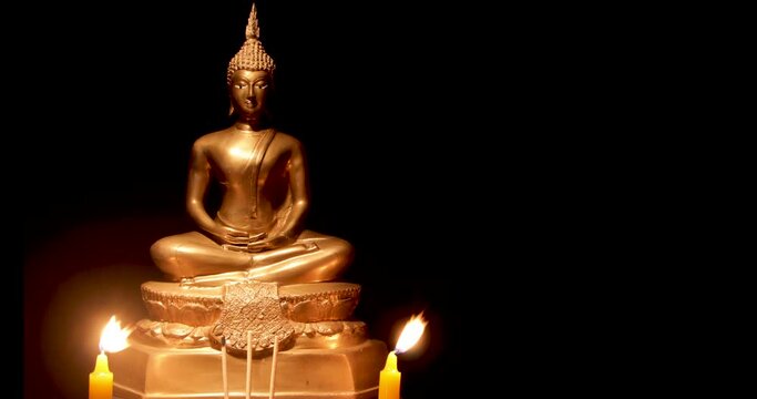 Stop motion photo,Burning incense and candles to pay homage to the Buddha image , black background,floating incense smoke