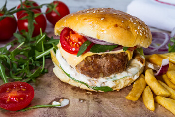 Homemade Beef Burger with Cheese and Chips on wooden background