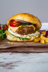 Homemade Beef Burger with Cheese and Chips on wooden background