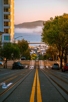 Amazing view of a sloping street in San Francisco, photographed in the middle on the tram tracks. San Francisco, USA - 21 Apr 2021