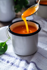 Carrot soup on a table in mugs. Homemade healty food