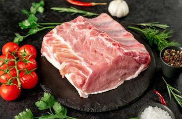 Raw whole pork steaks with ribs on stone background