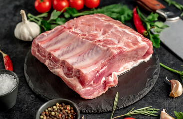 Raw whole pork steaks with ribs on stone background