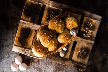 Easter Eggs with kaiser rolls and sesame seeds on retro crate. Top View