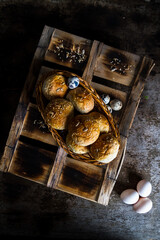 Easter Eggs with kaiser rolls and sesame seeds on retro crate. Top View