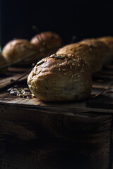 Whole wheat kaiser rolls with sesame seeds on retro crate sorted in line