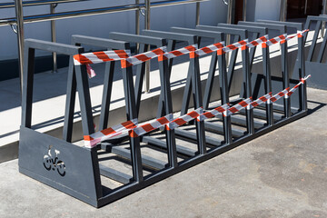 An empty bicycle parking lot wrapped in barrier tape. Bicycle parking is prohibited.