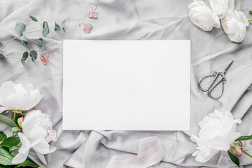 Obraz na płótnie Canvas White paper sheet flatlay, for mock-ups, peonies, A4