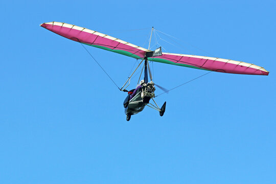 Ultralight airplane flying in a blue sky	