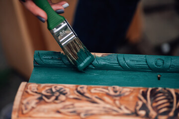 macro on a brush in paint and the process of refreshing an old box with monograms, restoring antique objects and moderate consumption. 