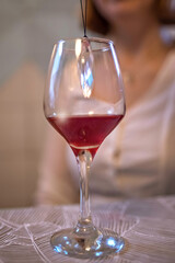 A glass of red wine on the table with a crystal inside