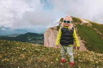 Child hiking in mountains travel family vacation lifestyle 2 years old toddler outdoor eco tourism