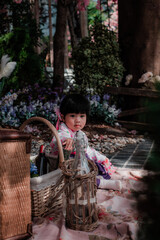 Adorable little girl wearing Japanese kimono in the park with soft focus.