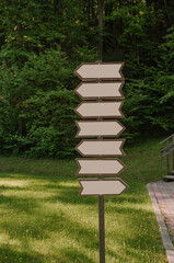 Rout pointer in the park. Wooden pointer with blank space for text.