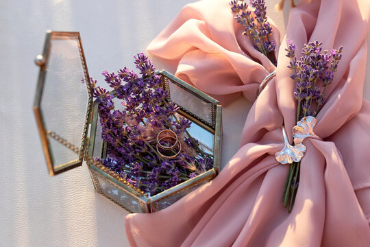 Layout from a box with flowers and gold rings of the bride and groom. Wedding concept.