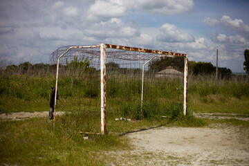 Rusted football goal on an abandoned field, forgotten by time.
