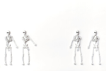 Dancing skeletons. Creative composition with white skeleton on the white background. Halloween or...