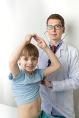 The pediatrician is on the examination of the child. The doctor listens to the lungs from the back....