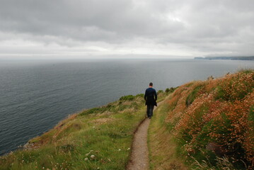 Man walking on coastal path in Padstow, United Kingdom