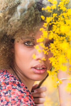 Portrait Of Etnic Afro Girl With Light Skin With Yellow Flowers