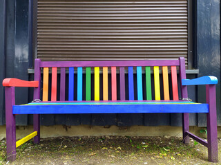 Colorful bench with different shiny colors as symbol for variety and diversity and Pride concept for tolerance and beautiful garden decoration seat with happy lifestyle of wooden furniture in parks