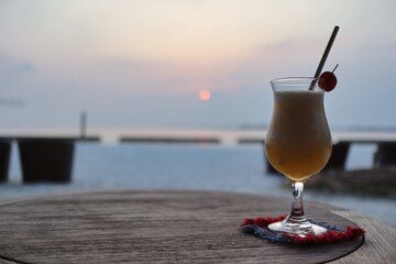 One Glass of Fruity Cocktail during Sunset in Maldives. Iced Beverage on Table in Maldivian Resort.