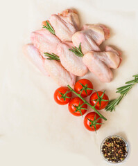 Raw chicken wings with tomatoes and spices. Flat lay on grocery healthy background