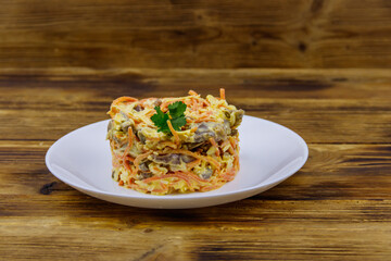 Tasty salad with pork heart, carrot in Korean, onion,  cheese and mayonnaise on wooden table