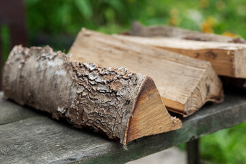 Logs of firewood lie on a bench in the street. Close-up. Picnic in nature.