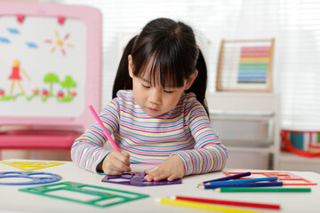 young girl drawing different shapes for homeschooling