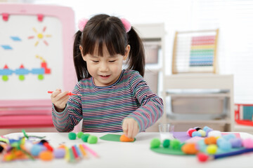 young girl hand makes caterpillar craft for home schooling