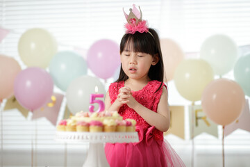 Obraz na płótnie Canvas young girl celebrating her 5th birthday at home