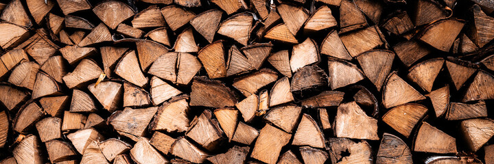 textured firewood background of chopped wood for kindling and heating the house. a woodpile with...
